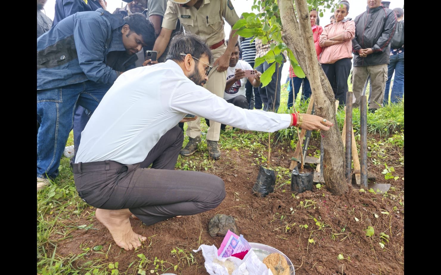 Piyush Somani planting a tree barefoot, with forest officials present